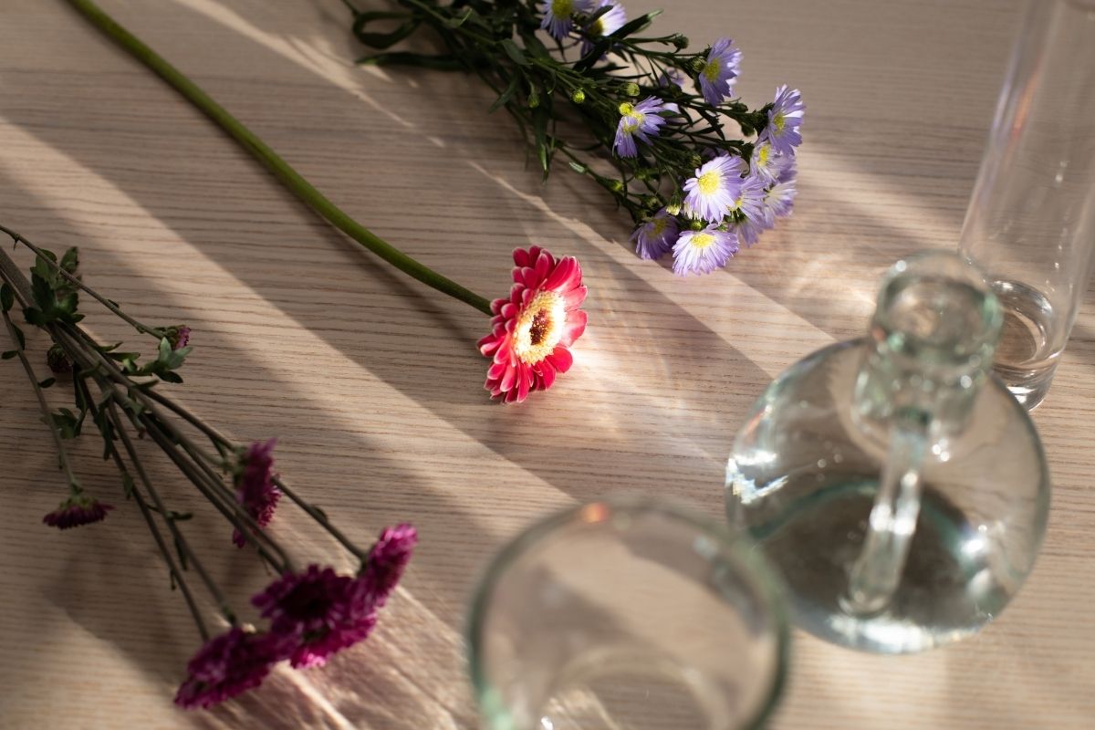 Arranjos de flores artificiais em vasos de vidro - Reprodução Canva